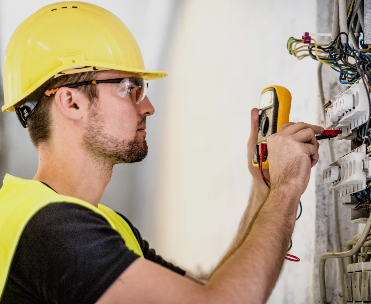 Man inspecting electrical connections with tools